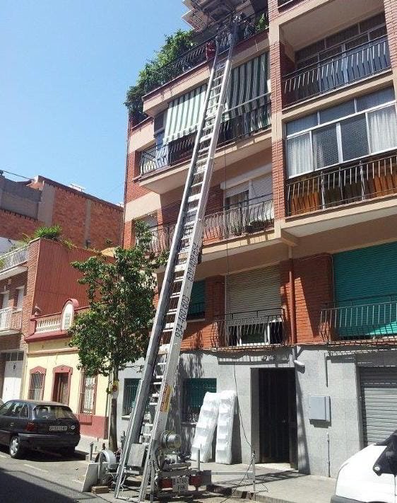 escalera mecánica subiendo muebles a un piso a través del balcón